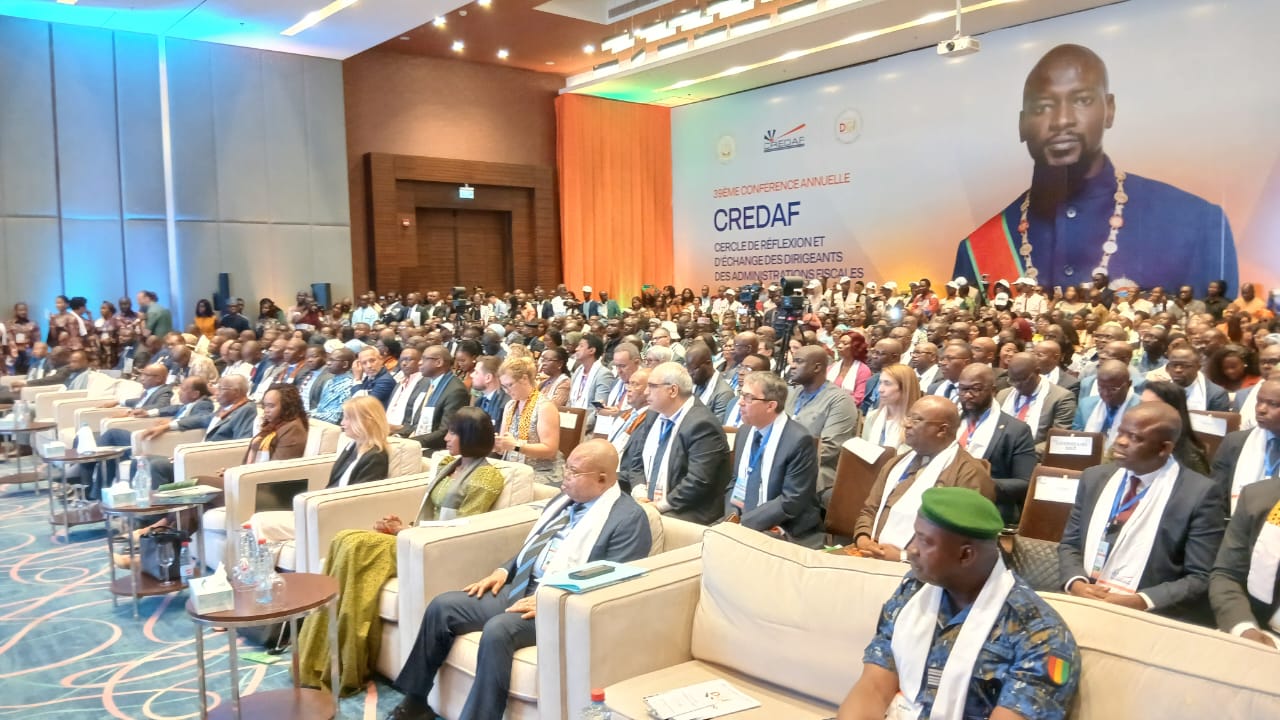 Finances publiques : le CREDAF mobilise les experts fiscaux face aux crises mondiales La Guinée accueille depuis le 9 juin la 39e Conférence annuelle du CREDAF, un rendez-vous majeur consacré aux enjeux de la mobilisation des recettes intérieures dans un environnement économique mondial marqué par de multiples incertitudes. Organisée à Conakry en collaboration avec la Direction générale des impôts (DGI), la rencontre rassemble responsables fiscaux, experts, partenaires techniques et financiers ainsi que plusieurs représentants gouvernementaux. Placée sous le thème « La gestion des risques axée sur la mobilisation des recettes intérieures en contexte de crise », cette conférence vise à permettre aux administrations fiscales des pays membres d’échanger sur les meilleures pratiques pour renforcer la résilience budgétaire des États face aux chocs économiques, géopolitiques et climatiques. À l’ouverture des travaux, la directrice générale des Impôts, Fatoumata Foula Diallo, a souligné que les pays en développement évoluent dans un contexte marqué par les tensions géopolitiques, les dérèglements climatiques, les contraintes budgétaires et les incertitudes monétaires. Selon elle, la raréfaction des ressources extérieures rend indispensable le renforcement des capacités nationales de mobilisation des recettes fiscales. Elle a estimé que la résilience des États repose désormais sur leur aptitude à sécuriser, diversifier et optimiser leurs ressources fiscales propres. Pour la responsable guinéenne, cette rencontre constitue une opportunité de partager des expériences et d’identifier des solutions concrètes pour mieux anticiper et gérer les risques qui pèsent sur les administrations fiscales. Prenant la parole à son tour, le Premier ministre guinéen, Amadou Oury Bah, a insisté sur la nécessité d’impliquer davantage les populations dans la stratégie de mobilisation des recettes intérieures. Il a rappelé que le financement des services publics repose historiquement sur l’impôt et que les citoyens contribuent déjà au développement local à travers diverses initiatives communautaires. Selon le chef du gouvernement, le véritable défi consiste à rapprocher davantage l’action publique des réalités sociales et culturelles afin que les populations se reconnaissent pleinement dans les missions de l’État moderne. Une meilleure compréhension du rôle de l’impôt pourrait ainsi favoriser le civisme fiscal et améliorer les ressources destinées au financement du développement. Les travaux, qui se poursuivront jusqu’au 12 juin, doivent déboucher sur des recommandations destinées à renforcer la mobilisation des recettes intérieures, notamment à travers une meilleure intégration du secteur informel dans l’économie formelle. Les participants examineront également plusieurs expériences internationales, notamment celles de la France, du Canada, de la Guinée et de l’Uruguay. Pour Barnabé Muakadi Muamba, le choix de cette thématique s’inscrit dans la nouvelle stratégie de l’organisation adoptée lors de sa 49e Assemblée générale tenue en 2025 à Kinshasa. L’objectif est de doter les administrations fiscales de mécanismes plus efficaces pour faire face aux crises tout en consolidant durablement les ressources nécessaires au développement des États membres.